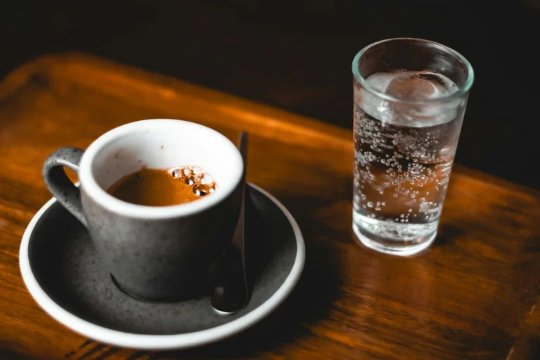 Taza de espresso junto a vaso de agua